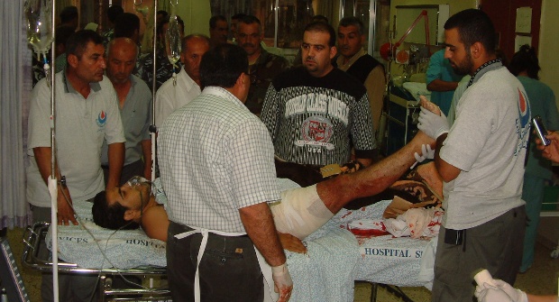 محمد خريس يمسك برجل أحد الجرحى الذين نقلهم إلى مستشفى مرجعيون (أرشيف كامل جابر)