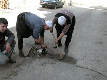  مواطنون ينظفون حفرة صغيرة لردمها