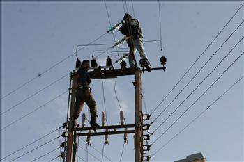  عاملان من كهرباء راشيا يعملان على إصلاح الأعطال