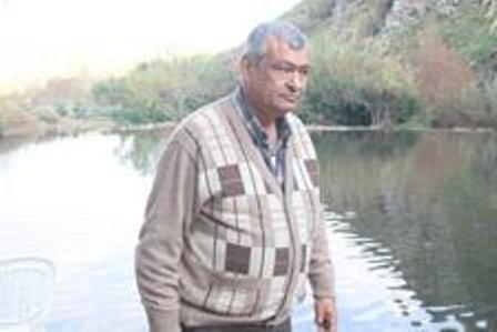 خليل عبدالله أحد أصحاب منتزه قرية حصن الوزاني أمام المياه الملوثة