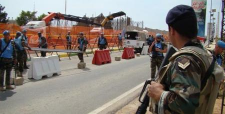 جندي لبناني يُراقب أعمال قوات الاحتلال الإسرائيلي ببناء الجدار في منطقة كفركلا