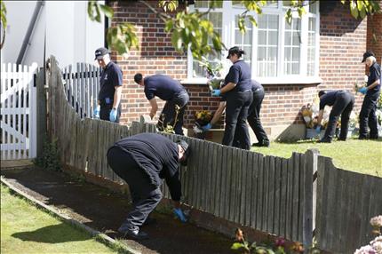 عناصر من الشرطة البريطانية يفتشون حديقة منزل سعد الحلي في جنوب شرق بريطانيا امس (ا ف ب)