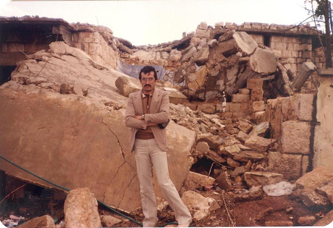 الكاتب سهيل علي غصن أمام أنقاض بيتهم  في الخيام قبل إعادة بنائه