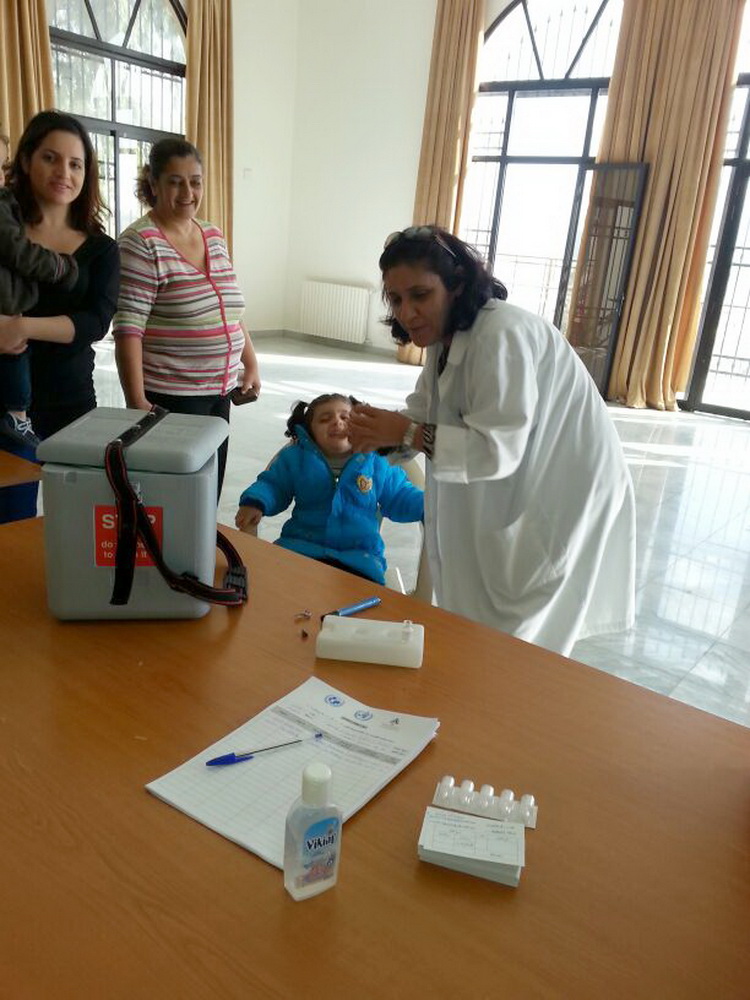 ممرضة من جمعية نور تعطي جرعة لطفلة من منطقة مرجعيون