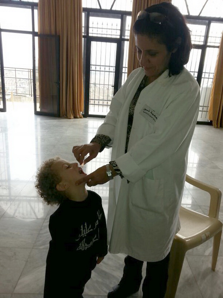 إعطاء جرعة بالفم لطفلة ضد شلل الاطفال