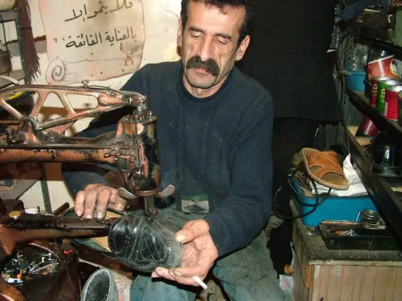 أبو مروان خياط يجلس خلف ماكينة الدرز