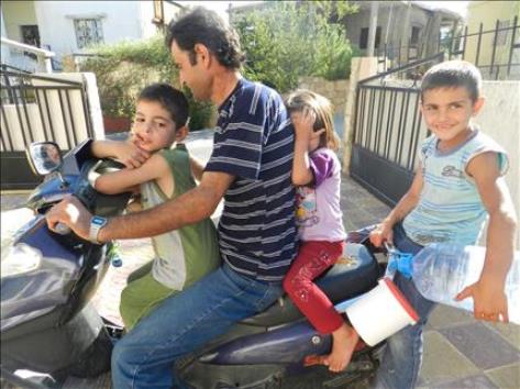 ركان فوق دراجته مع ثلاثة أطفال (طارق أبو حمدان)