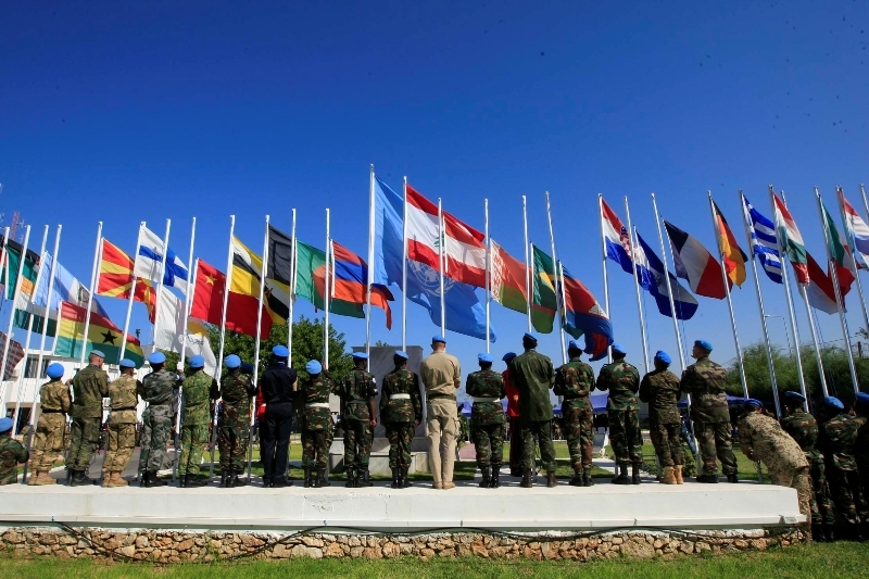  جنود دوليون من 38 دولة يمثلون قوات اليونيفيل امام أعلام بلادهم