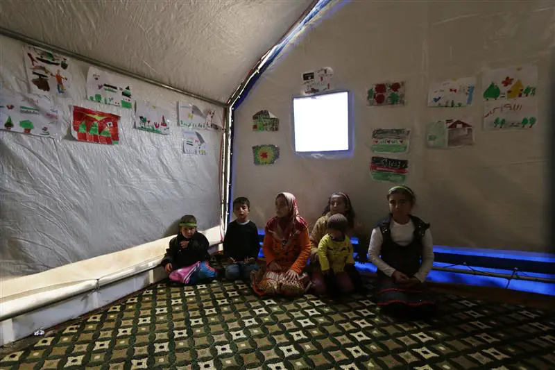 اطفال نازحون داخل خيمة في ريف ادلب امس (رويترز)