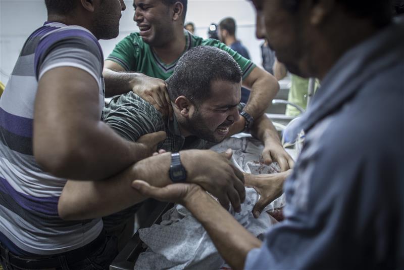 مسعفون في مشرحة مستشفى الشفاء في غزة قرب جثامين 3 اطفال من عائلة شحيبر وطفل رابع من عائلة الحميدي استشهدوا في غارة اسرائيلية امس (ا ف ب)