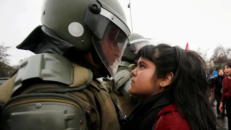 متظاهرة تتحدى شرطيا من مكافحة الشغب بسانتياغو في شيلي، يوم 11 سبتمبر