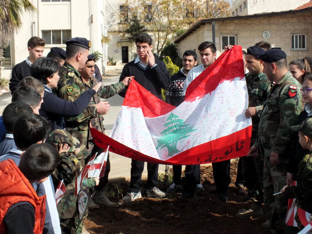 طلاب مدرسة الراهبات يقدمون علما لبنانيا عليه تواقيعهم