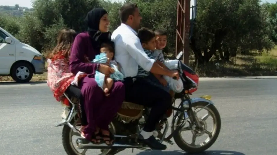 الأب يقود الدراجة وأمامه وخلفه باقي العائلة