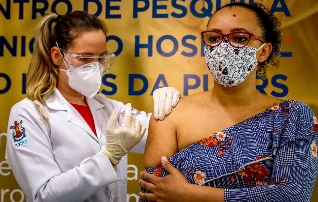 العاملة الصحية والمتطوعة فابيانا سوزا تتلقى لقاحا ضد كوفيد- 19 من إنتاج الشركة الصينية سينوفاك بيوتيك، في مستشفى ساو لوكاس في بورتو أليغري جنوب البرازيل (8 آب 2020، أ ف ب)