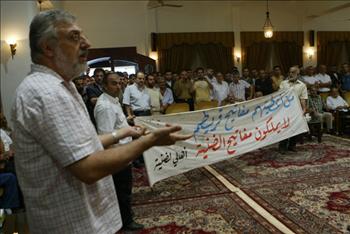 الصمد يعرض لافتة عليها بقع دم خلال المؤتمر الصحافي