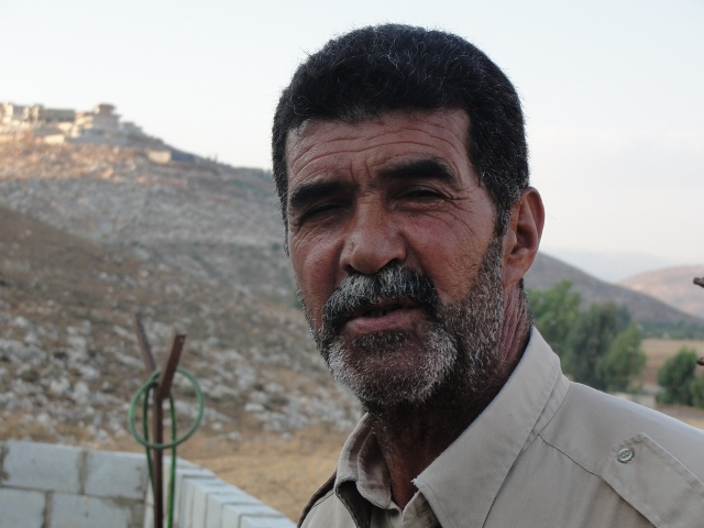 أبو حسين في المزرعة، ويظهر في أعلى الصورة دارة جاره محمد الصفاوي