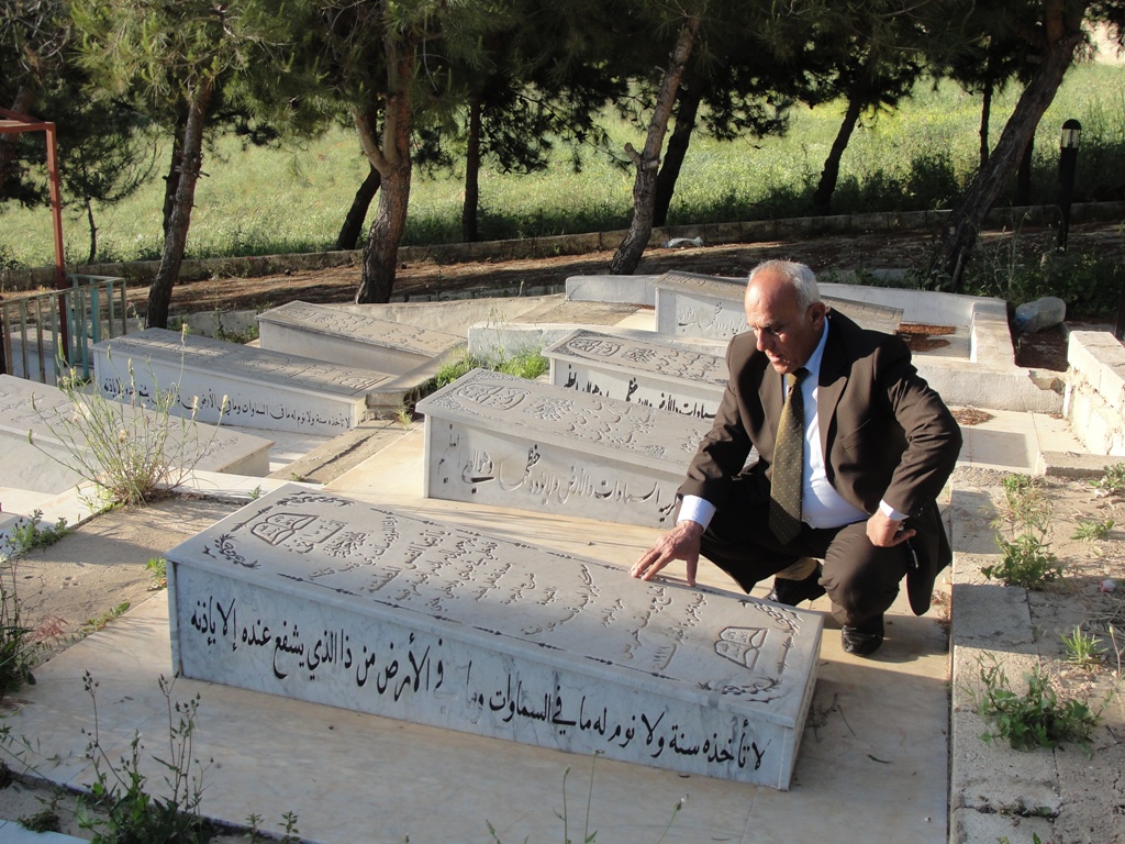 أبو محمد علي يوسف خريس يقرأ الفاتحة على قبر المرحومة والدته شهيدة الإجرام الصهيوني