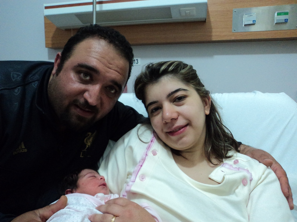 علي كامل أبو عباس وزوجته حنان حمد ومولودتهما البكر أميرة