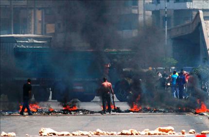 سائقون يقطعون طريق طرابلس بالاطارات المشتعلة احتجاجاً على ارتفاع سعر صفيحة البنزين (عمر ابراهيم) 	
