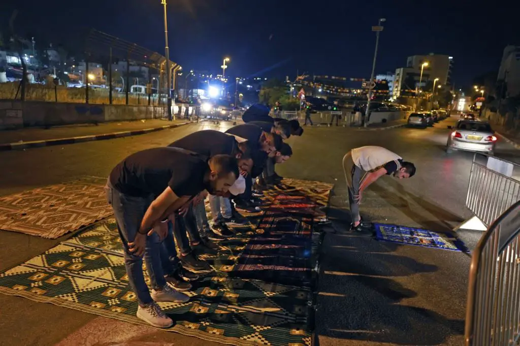 شبّان فلسطينيّون يصلّون في باحة المسجد الأقصى (أ ف ب)