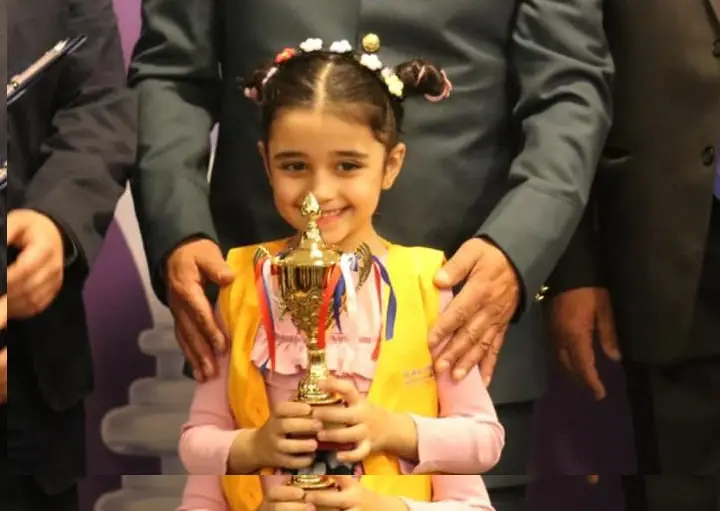 المشتركة جسيكا قبيسي من جمعية كلمات تحمل الكأس بعد أن حققت المركز الاول في بطولة لبنان للشطرنج  للعام 2023 فئة ما دون ٦ سنوات والتي نظمها الاتحاد اللبناني للشطرنج
