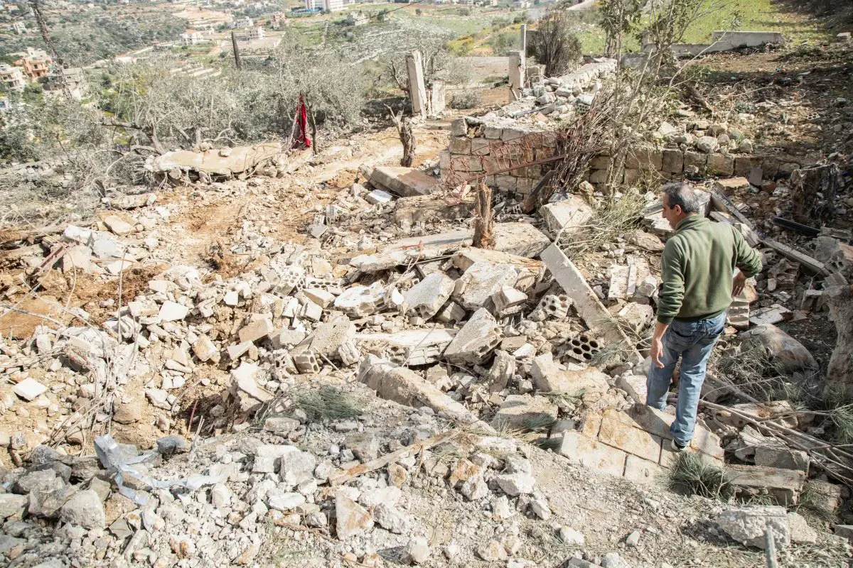 رجل يتفقّد الدمار الذي أعقب غارة جوية إسرائيلية على قرية الصوانة في جنوب لبنان (أ ف ب).