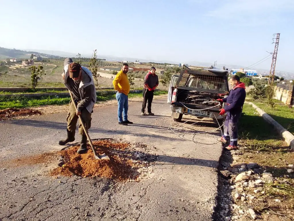 عمال من بلدية الطيبة يقومون بإصلاح الحفر التي خلفها القصف الاسرائيلي على البلدة