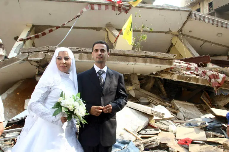 عريس وعروس وخلفهما الدمار. الصورة تعود للعام 2006 أثناء حرب تموز (المصدر أندبندنت)