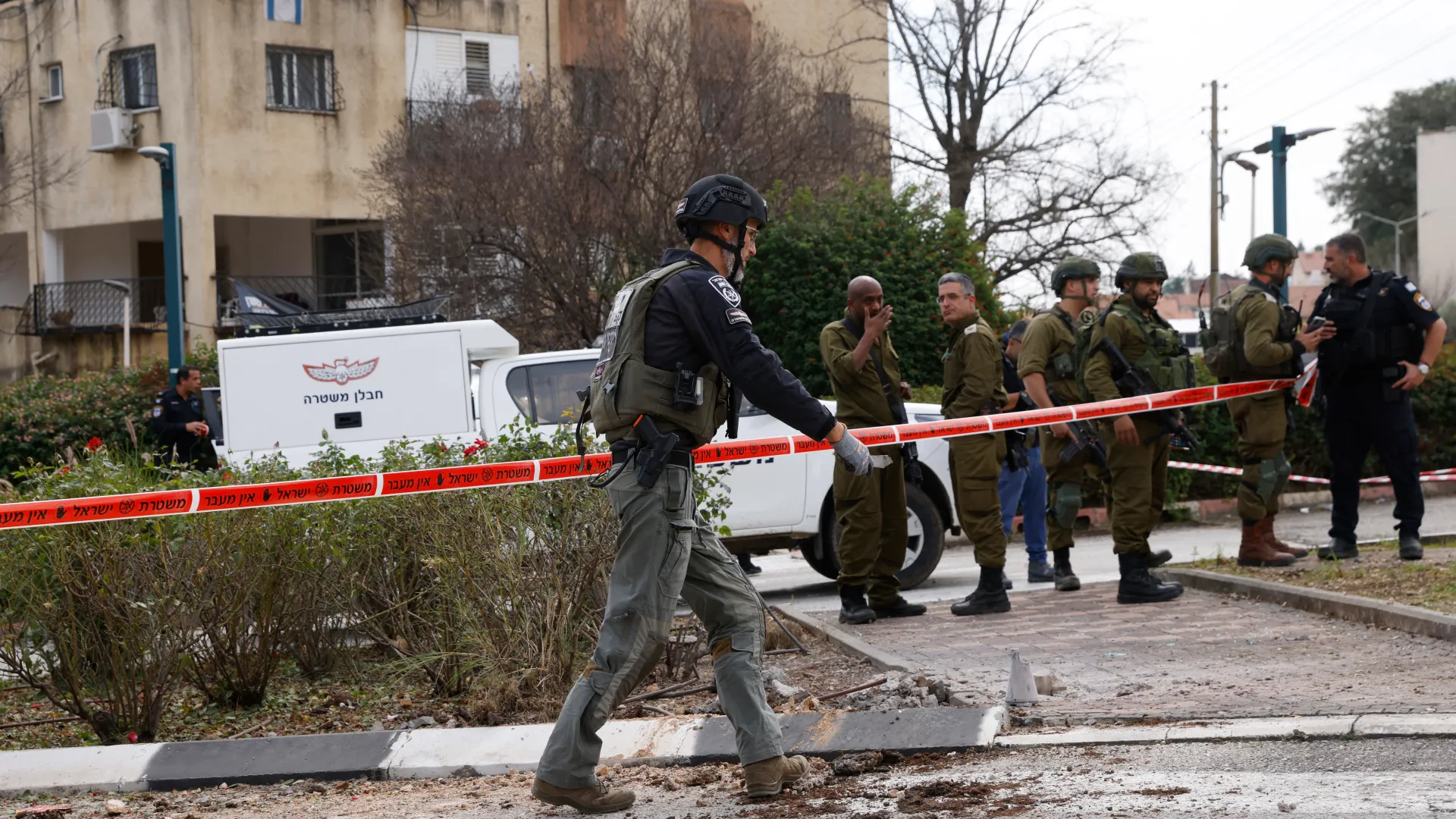 عناصر من الجيش الإسرائيلي والشرطة يتفقدون موقع سقوط الصواريخ في كريات شمونة (الفرنسية)