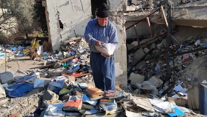 لا يبارح أطلال منزله الذي سوته الطائرات الإسرائيلية بالأرض باحثاً عن نتف من كتبه (حسين سعد)