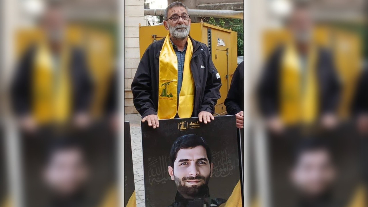 أحمد ترمس ممسكًا بصورة نجله الشهيد حسن