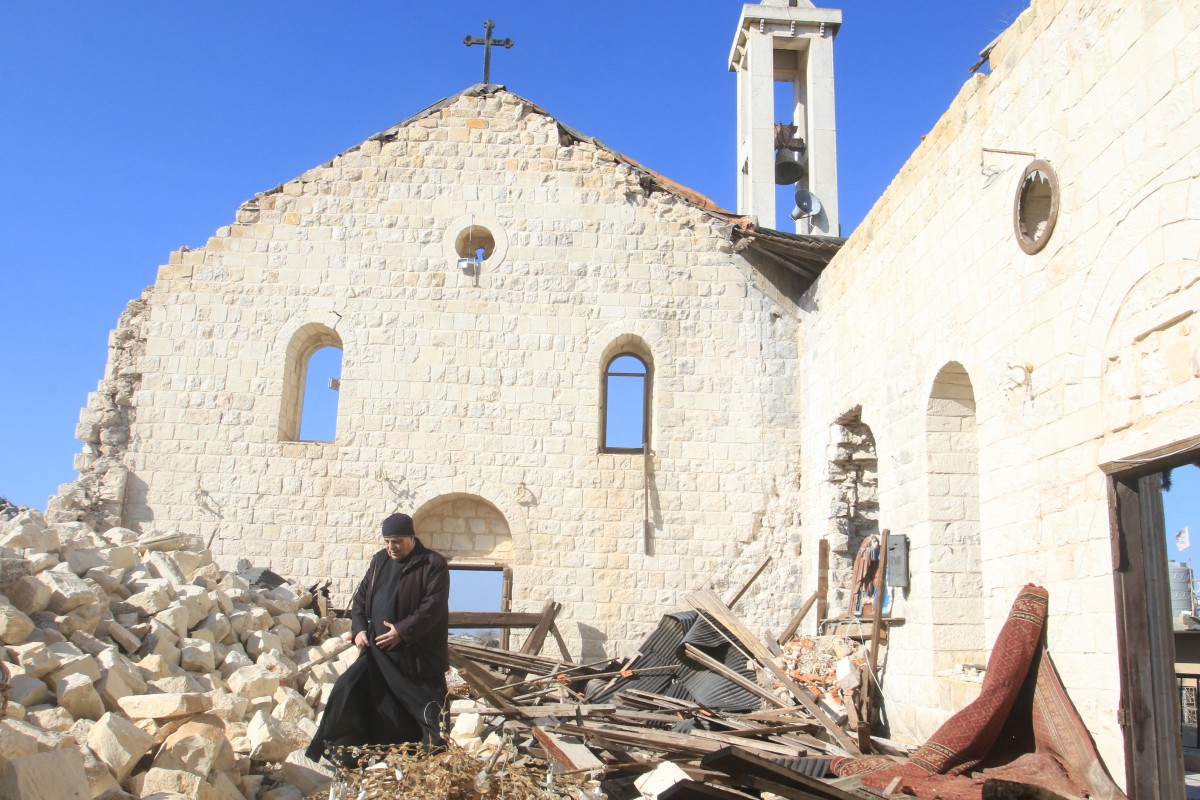 كاهن أمام كنيسة مدمرة في جنوب لبنان (ا ف ب)