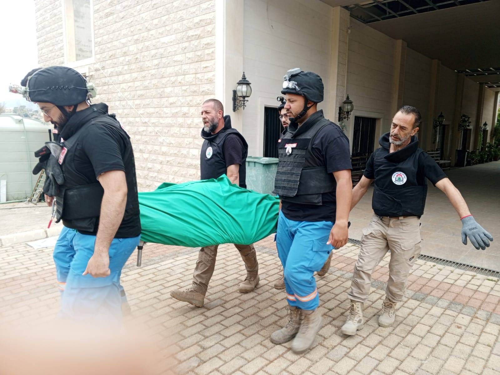مسعفون ينقلون جثة قبل دفنها جنوب لبنان (كامل جابر - اندبندنت عربية)