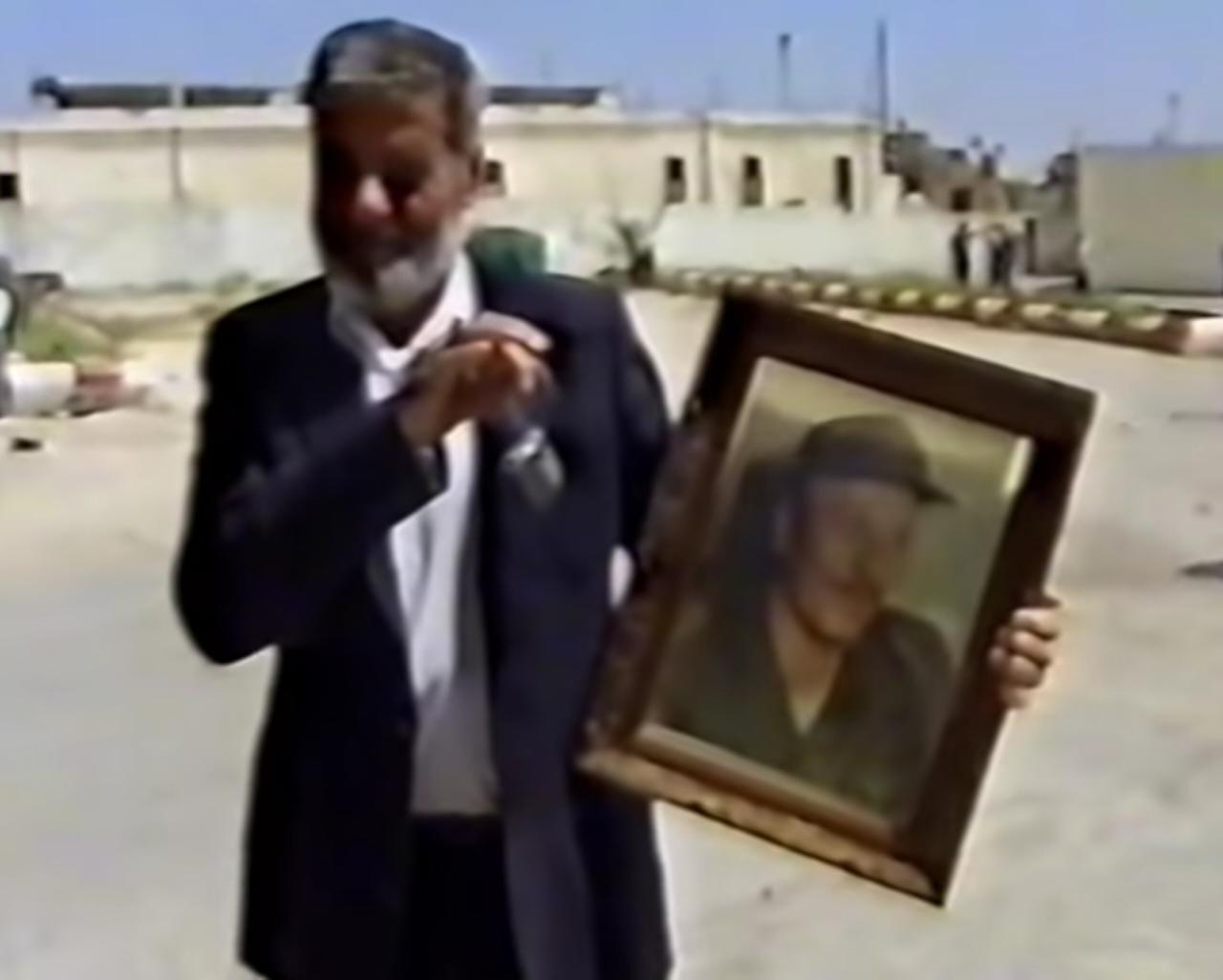 المرحوم أبو عدنان عبود حاملا صورة للبائد سعد حداد ليقول له: «زمنك وزمن أمثالك ولّى إلى مزبلة التاريخ ولن يعود، ونبقى نحن أهل الأرض صناع تاريخنا الأشرف في عالم الأحرار»