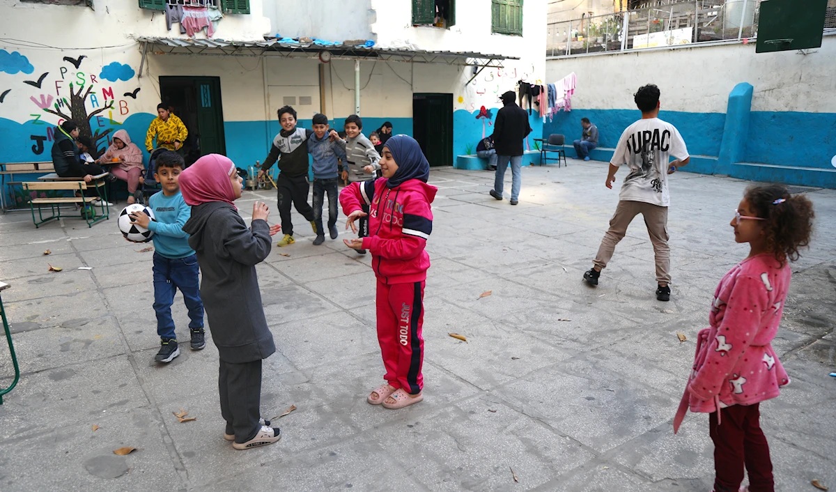 أطفال يلهون في باحة مدرسة مستخدمة كمركز نزوح (مروان بو حيدر)